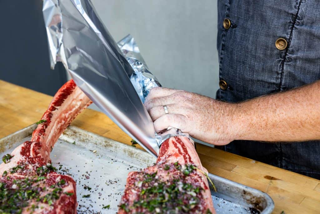 Wrapping the tomahawk steak bones in aluminum foil